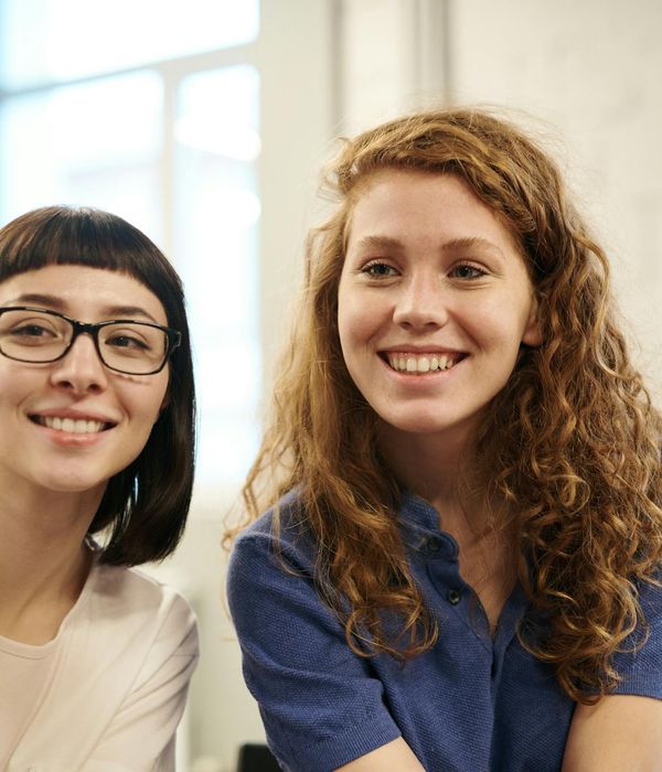 Diverse group of people smiling and looking relaxed in a modern setting.